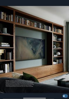 a living room filled with furniture and bookshelves next to a flat screen tv