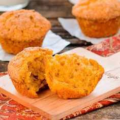 two muffins sitting on top of a wooden cutting board