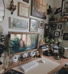 a desk with a keyboard, mouse and various pictures on the wall above it in a home office