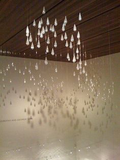 an art exhibit with many hanging glass drops