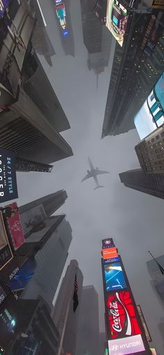 an airplane is flying through the sky over some buildings and billboards in new york city