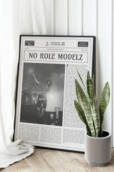 a plant in a pot next to a newspaper with the word no role modelz on it