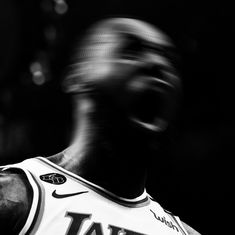 a black and white photo of a basketball player with his head tilted back to the side