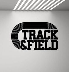 the track and field logo is shown in black on a white wall, with light coming from above it