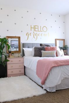 a bedroom with polka dot wall decals and pink bedding