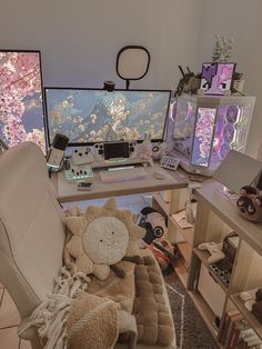 a computer desk with two monitors and stuffed animals on the chair in front of it