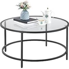 a coffee table with a glass top and metal frame around the bottom, holding a tea pot