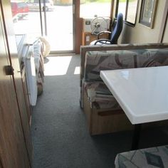 the inside of a camper with couches, tables and chairs