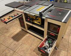 a workbench with tools in it on the floor next to a tool cabinet