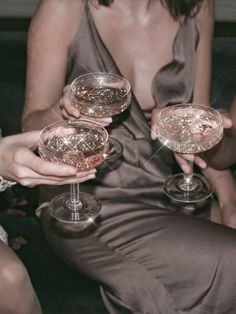 two women are holding wine glasses in their hands