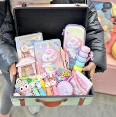 a person holding a suitcase filled with toys