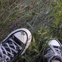 two pairs of shoes are standing in the grass