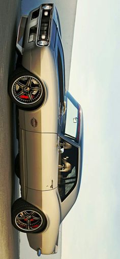 an old car parked next to a wall