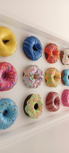 there are many different types of donuts hanging on the wall in front of them