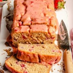 sliced loaf of strawberry banana bread sitting on top of a cutting board next to a knife