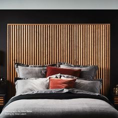 a bed with two nightstands and a headboard made out of wood slats