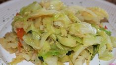 a white plate topped with cabbage and vegetables