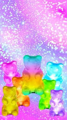 colorful gummy bears sitting on top of each other in front of a pink and blue background