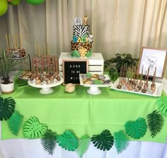 a green table topped with lots of desserts