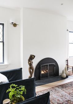 a living room filled with furniture and a fire place next to a wall mounted fireplace