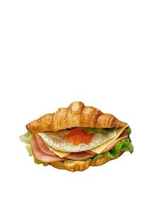 a croissant sandwich with meat, cheese and lettuce on it's side