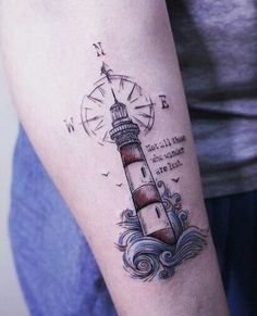 a woman's arm with a lighthouse tattoo on it