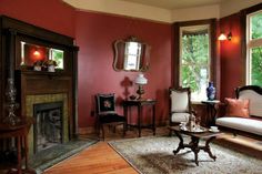 a living room filled with furniture and a fire place in front of two large windows