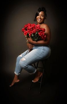 a woman sitting on a chair holding a bunch of roses