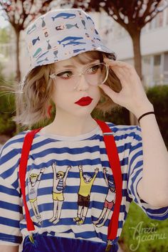 a young woman wearing glasses and a hat