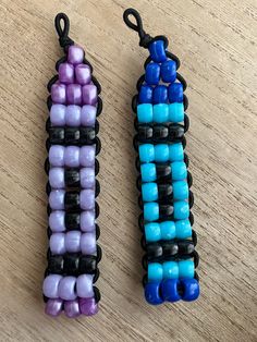 two pieces of beaded jewelry sitting on top of a wooden table next to each other