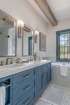 a bathroom with blue cabinets and marble counter tops