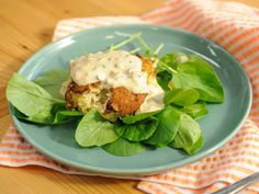 a blue plate topped with lettuce and meat patties covered in ranch dressing