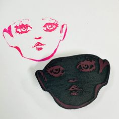 a drawing of a woman's face next to a piece of felt with eyes drawn on it