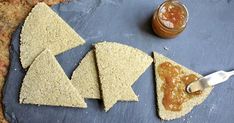 three pieces of bread with peanut butter and jelly on them next to a jar of jam