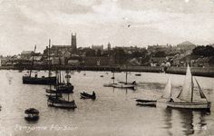 an old black and white photo of sailboats on the water in front of a city