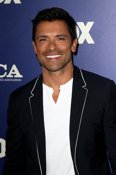 a smiling man in a black jacket and white shirt