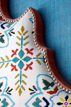 an embroidered pillow with beading on the back of it's neck and sides