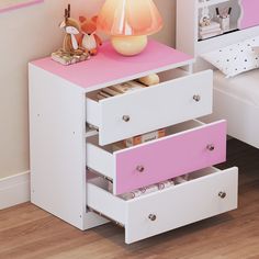 a pink and white dresser with drawers in a child's playroom or bedroom