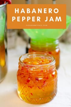 a jar filled with orange liquid sitting on top of a table next to other jars