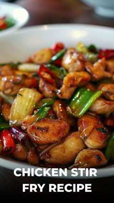 chicken stir fry in a white bowl with green onions and red peppers on the side