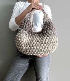 a woman holding onto a crocheted purse