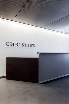 an empty room with a reception counter in front of the sign that says christie's