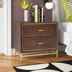 This nightstand showcases metallic accents that complement the chic finish to create a mid-century modern addition to your bedroom. It's made from engineered wood and features a brass-finished metal base with four legs and a wraparound support bar. A metal inlay behind the drawers matches the legs and adds to the retro aesthetic. The two drawers have bar pulls, and offer plenty of out-of-sight storage for your nighttime essentials. It measures 21.5" tall, so it'll fit next to low-profile bed fra Low Profile Bed Frame, Low Profile Bed, Safavieh Furniture, Walnut Nightstand, Bedside Storage, 2 Drawer Nightstand, Wood Nightstand, Bedroom Night Stands, Drawer Nightstand