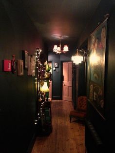 the hallway is decorated with christmas lights and pictures on the wall, along with a chair