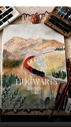 the hogwarts express poster is next to some paintbrushes and watercolor paints