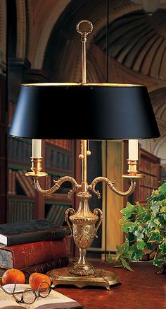 a table lamp sitting on top of a wooden desk next to an orange and book