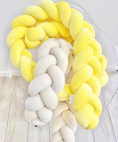 a bunch of yellow and white pillows sitting on top of a wooden floor