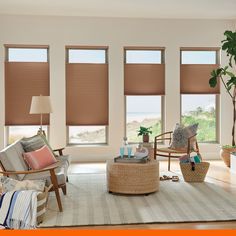 a living room filled with furniture and large windows covered in shades of light brown blinds