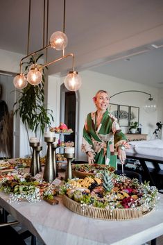 a woman standing in front of a table filled with food