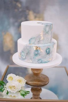 a three tiered white and blue marbled cake